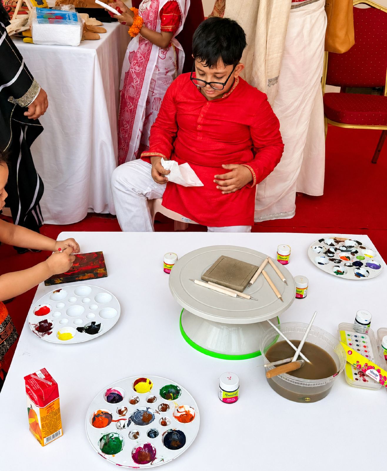 Children learning pottery at an inclusive art workshop