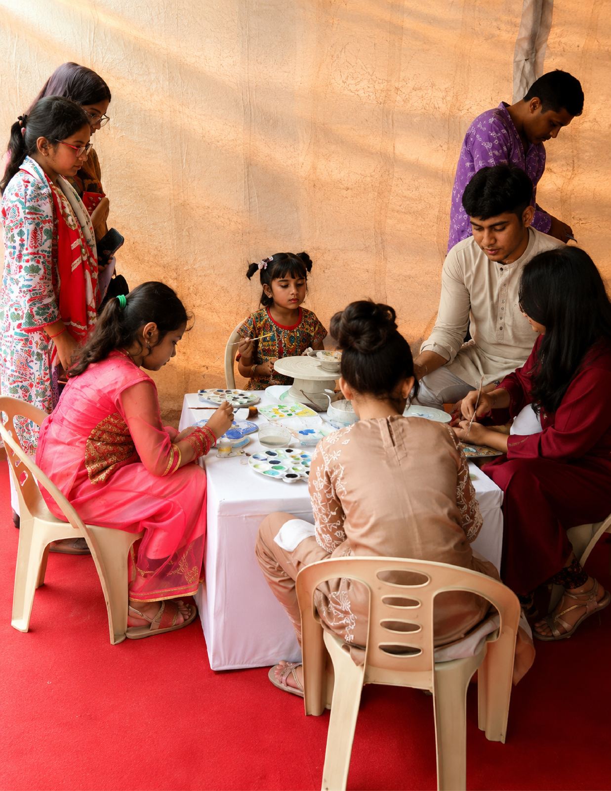 Families painting ceramics at the Boishakh Festival workshop